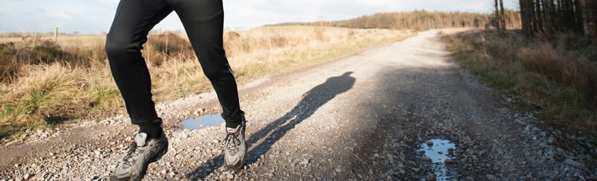 Person jogging down gravel road